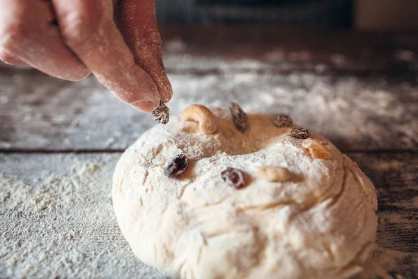 Decorating raw cake with dry fruits close-up