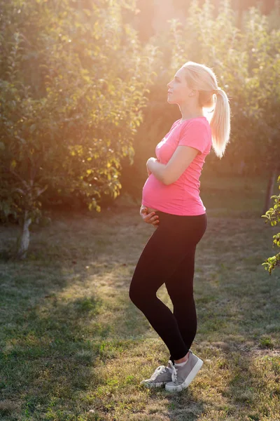 Terhes nő élvezi a sunrise Garden — Stock Fotó