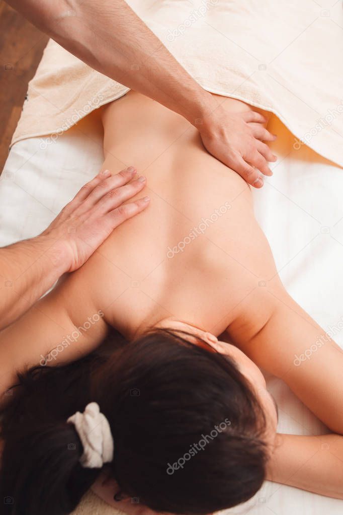 Masseur massaging female back top view