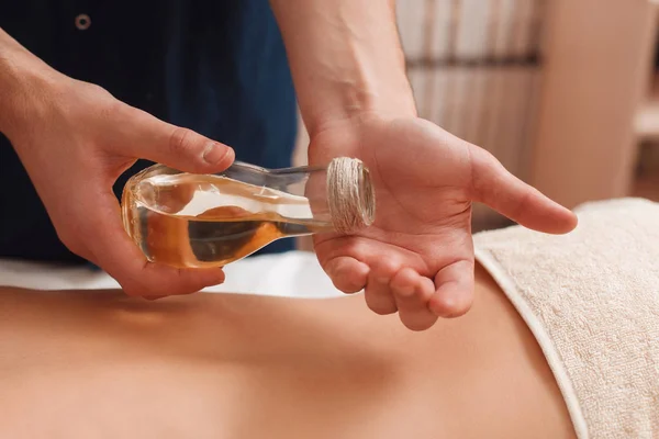 Masajista vertiendo aceite de aroma a mano primer plano — Foto de Stock