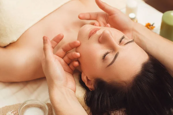 Портрет молодої жінки, що насолоджується масажем обличчя — стокове фото
