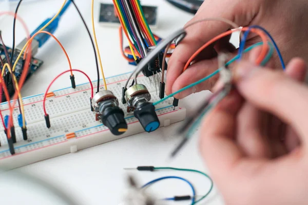 Hands connecting wires to breadboard closeup — Stock Photo, Image