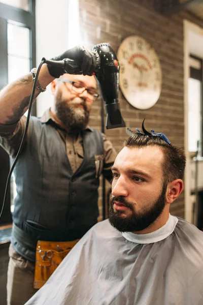 Стильний перукар сушіння волосся в перукарні — стокове фото