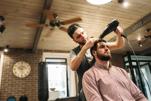 Стиліст сушіння волосся клієнтів в салоні вільне місце — стокове фото