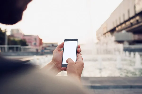 Teléfono con pantalla en blanco en las manos sobre el hombro —  Fotos de Stock