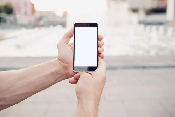 Manos sosteniendo la pantalla en blanco teléfono inteligente primer plano — Foto de Stock