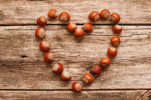 Heart made of hazelnuts on wood flat lay Royalty Free Stock Images