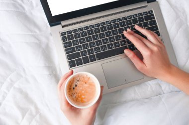 Kahve fincanı laptop ile el, sabah haberleri kontrol