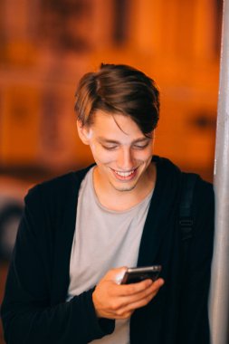 Gece şehirde smartphone ile gülümseyen adam