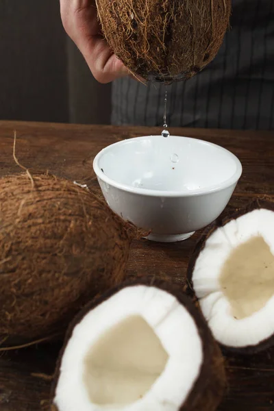 Свежая кокосовая вода, льющаяся в белую миску — стоковое фото