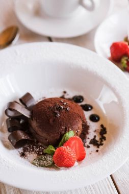 Dekorasyonu ile beyaz tabakta çikolatalı fondan