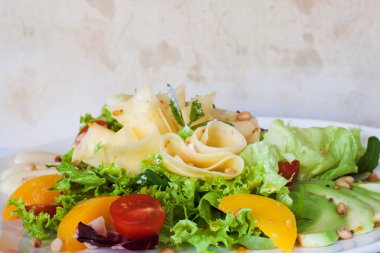 Yeşil salata ile peynir ve meyve plaka üzerinde