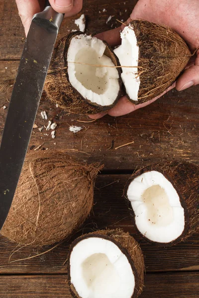 Coco quebrado por faca no fundo de madeira — Fotografia de Stock