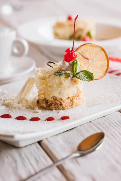 Cremiges orangefarbenes Dessert auf quadratisch geschnittenem Teller — Stockfoto