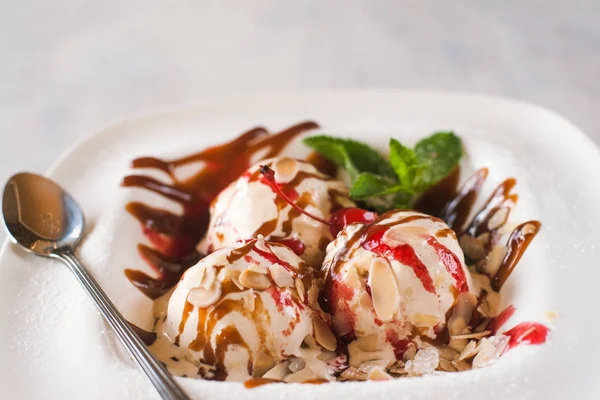 Sweet icecream balls with caramel and fruit syrup — Stock Photo, Image