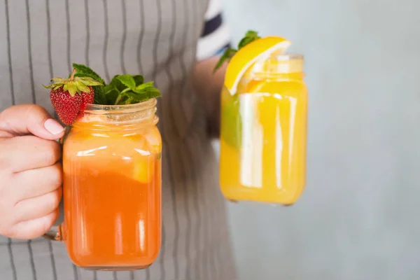 Serveur apporte des pots de cocktails de fruits dans les mains — Photo