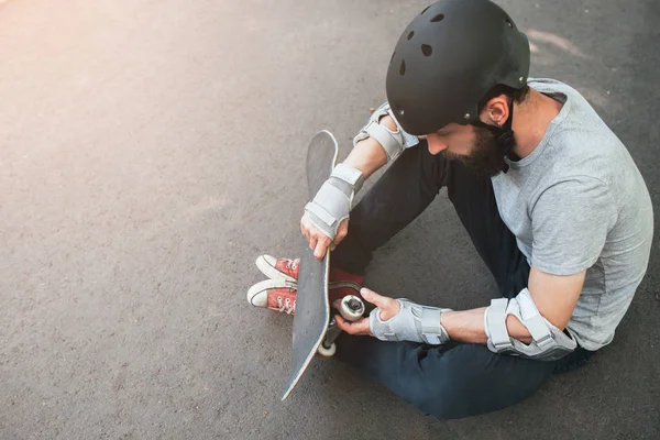 Profi-Skater checkt sein Skateboard — Stockfoto