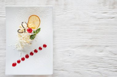 Beyaz ahşap masa üzerinde krem turuncu tatlı