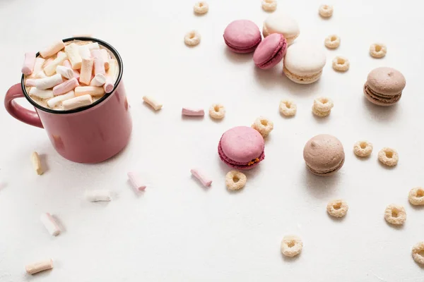 Lahodné latte s makronky na bílém stole — Stock fotografie