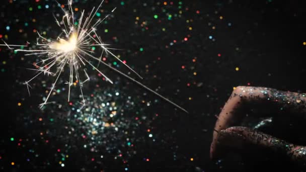 Vuurwerk sparkler op feestelijke glinsterende achtergrond — Stockvideo