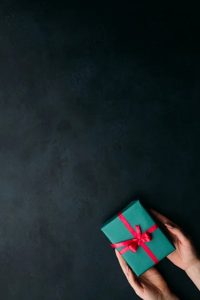 Presentando un elegante regalo sobre fondo oscuro — Foto de Stock