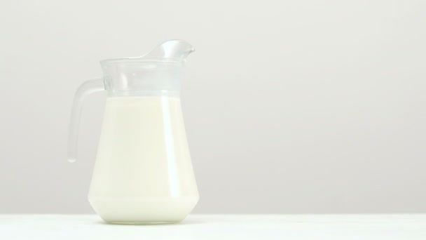Frasco de leche de vidrio fondo blanco lácteos orgánicos — Vídeo de stock