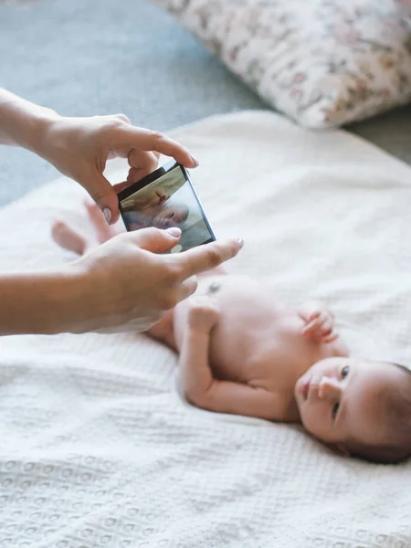 Mãe tirar uma foto smartphone de seu bebê recém-nascido — Fotografia de Stock