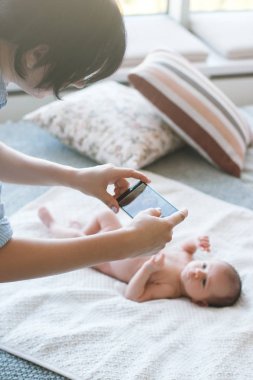 annesi onun yeni doğan bebek smartphone fotoğrafını almak