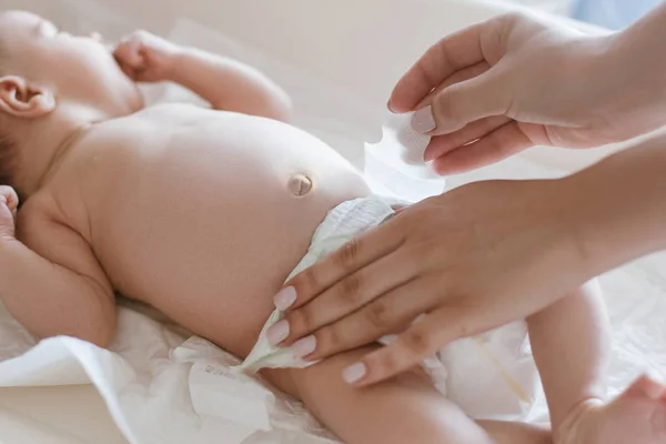 Mor ændrer bleer til hendes nyfødte baby - Stock-foto