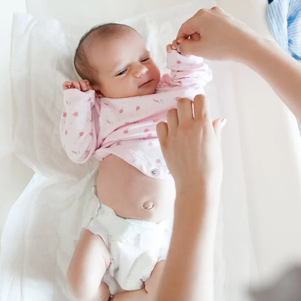 Mutter kleidet ihr Neugeborenes sorgfältig ein — Stockfoto