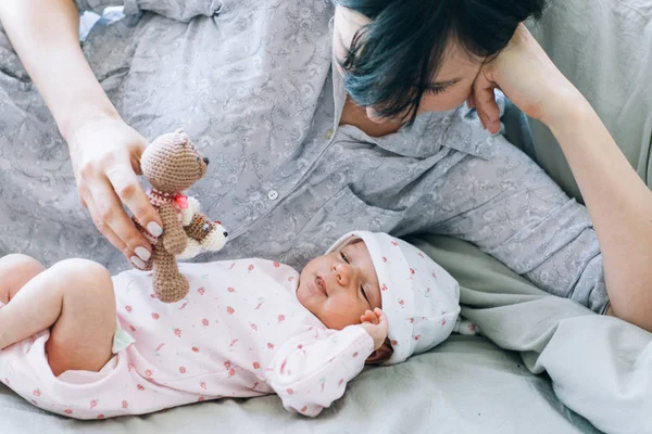 Madre jugar con su bebé recién nacido un osito de peluche juguete — Foto de Stock