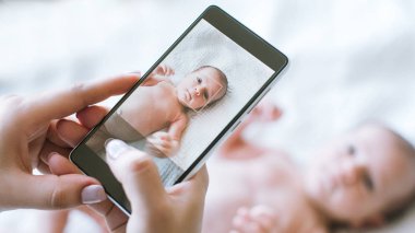 annesi onun yeni doğan bebek smartphone fotoğrafını almak