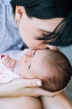 Anne, yavaşça yeni doğan bebeği öper