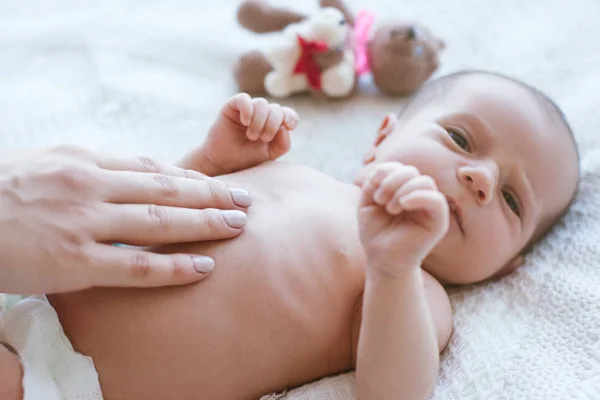 Moeders handen aai zachtjes de pasgeboren baby — Stockfoto