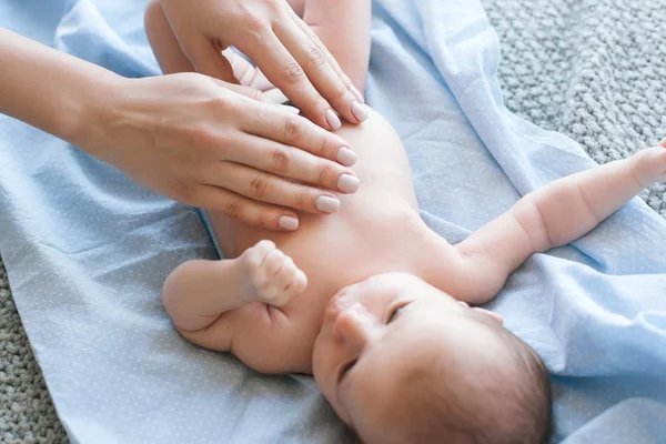 Mutter macht Körpermassage für ein neugeborenes Baby — Stockfoto