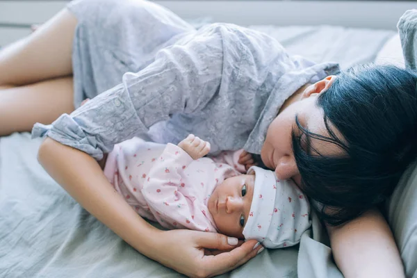 Uma mãe dormir durante o dia com seu bebê recém-nascido — Fotografia de Stock
