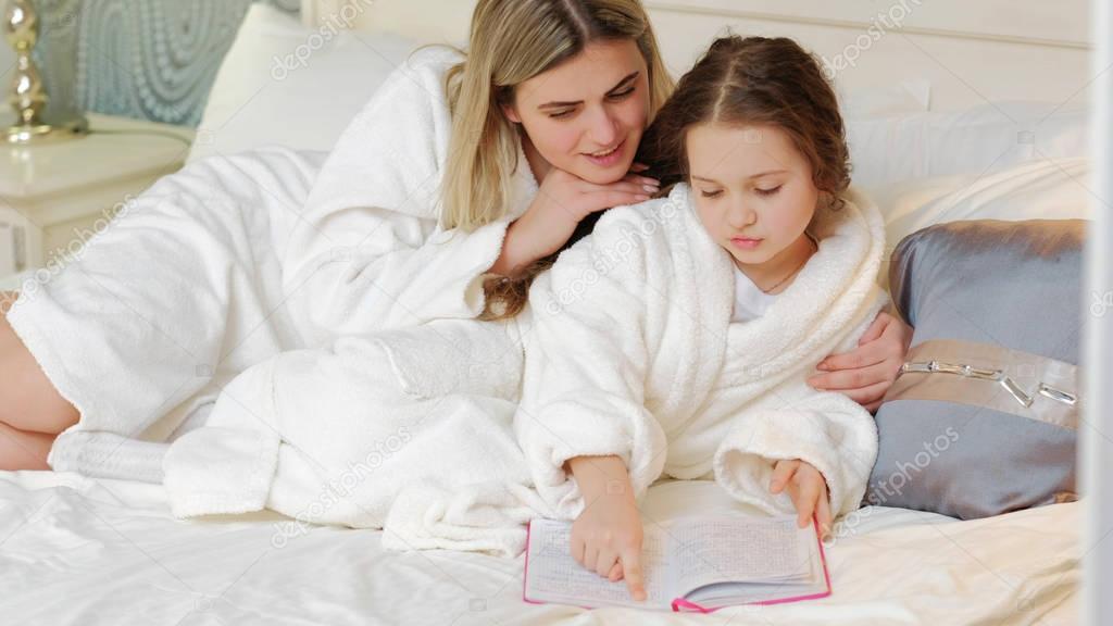 child bedtime story mom daughter read together