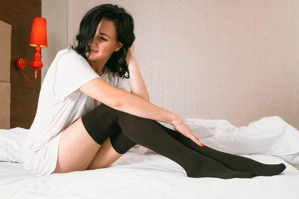 Romantic morning woman t shirt black stockings bed — Stock Photo, Image