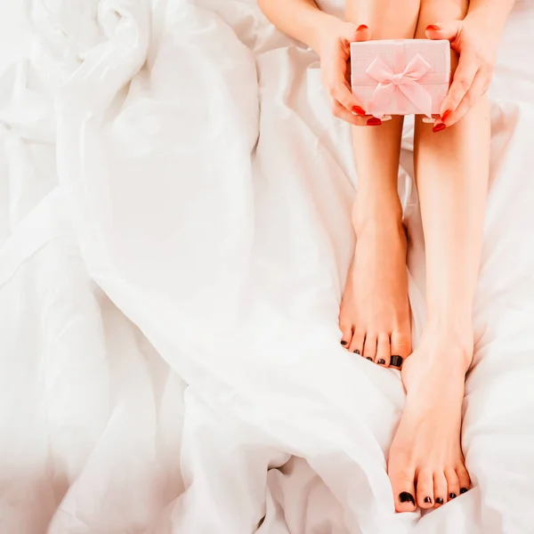 Žena speciální den žena holé nohy růžová dárková krabice — Stock fotografie