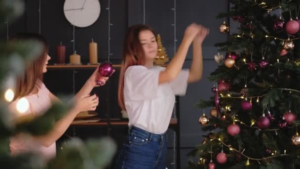 Зимние каникулы девушки-подростки украшают елку — стоковое видео