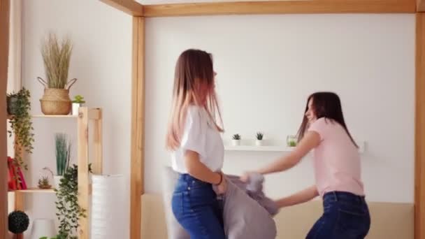 Girls pillow fight playful friends fun bedroom — Stock Video