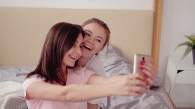 Kız kardeşler boş zamanlarında neşeli genç kızlar akıllı telefon.