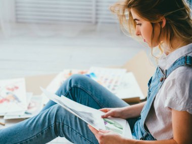 Sanat terapisi düşünen kadın evde oturup resim yapıyor.