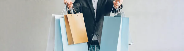 Preto sexta-feira compras homem sacos cinza fundo — Fotografia de Stock