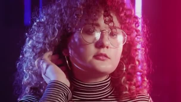 80s stijl meisje portret vrouw krullend haar neon gloeien — Stockvideo