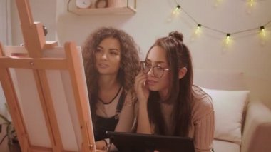 Güzel sanatlar sınıfındaki kadınlar tablet resim öğreniyor.