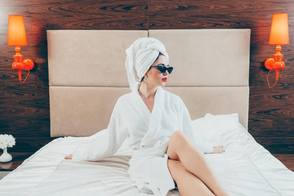 Luxury lifestyle woman bathrobe sunglasses bed — Stock Photo, Image