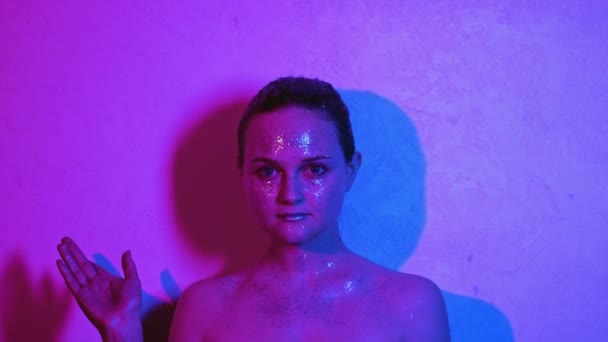 Model neon lighting woman shiny skin making choice — Stockvideo