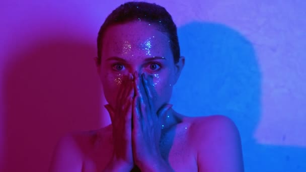 Glitter art portrait scared woman shiny skin light — Stockvideo