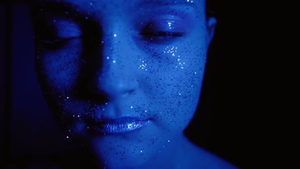 Glitter art makeup woman shimmering face blue glow — Stock Video